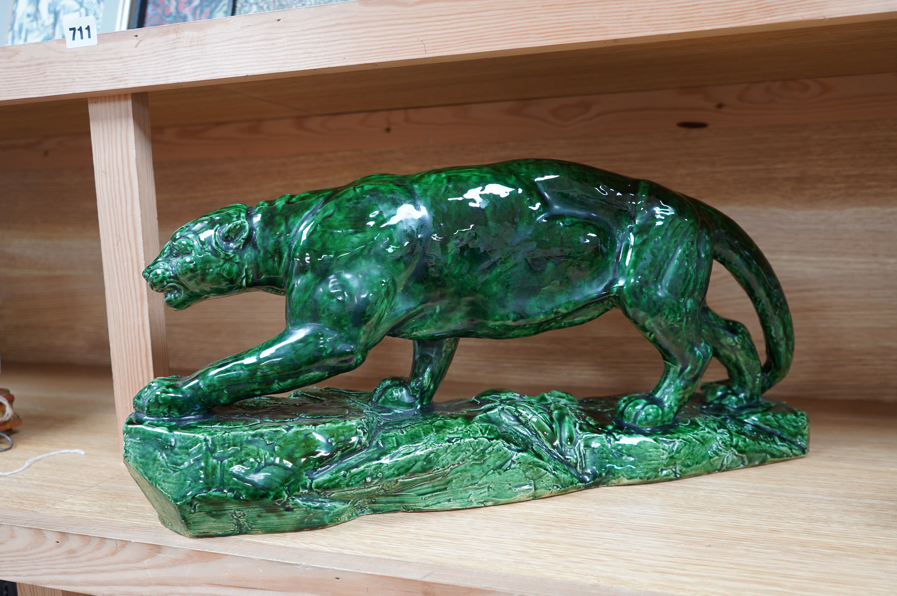 A French green glazed earthenware panther, indistinctly signed, 55cm wide. Condition - good